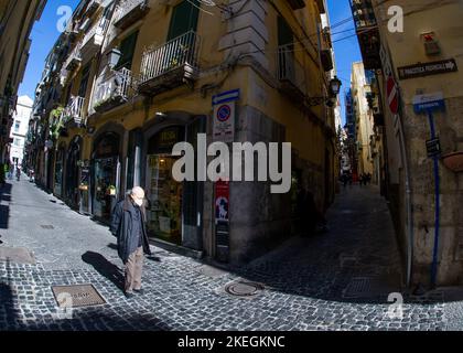 04 2022 aprile - Napoli Italia - la strada affollata una mattina con un sacco di scooter e persone a piedi per lavorare accanto a vecchi edifici colorati Foto Stock