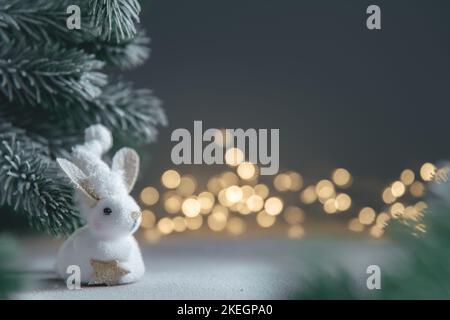 Un coniglio simbolo di 2023 tra le luci, ghirlande, alberi di Natale, calendario cinese anno simbolo con spazio copia Foto Stock