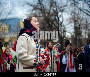 Bella ragazza sorridente in abiti tradizionali rumeni alla sfilata annuale delle tradizioni invernali in Moldova Foto Stock