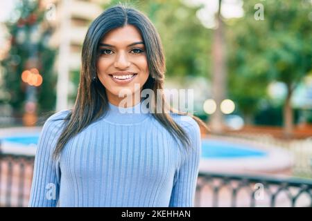 Bella donna ispanica sorridente confidente al parco Foto Stock
