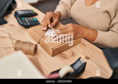 Medio età ispanica donna ecommerce business worker preparare il pacchetto in ufficio Foto Stock