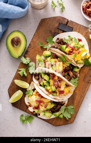 Tacos per colazione con salsiccia, uova, pancetta e avocado Foto Stock