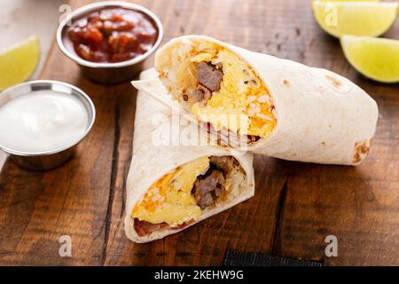Burrito per colazione con salsiccia, uova, hashbrown e formaggio Foto Stock