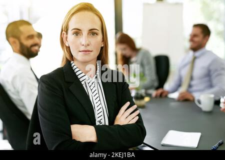 In testa alla riunione con seria fiducia. Ritratto di una donna d'affari che ha una riunione formale in una sala consiliare. Foto Stock