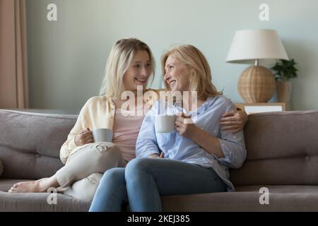 Madre e figlia giovane adulto bevono il tè e parlano Foto Stock