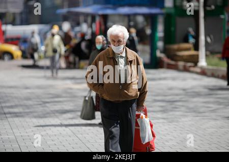 Bucarest, Romania - 16 aprile 2020: Gli anziani che indossano maschere protettive fanno il loro shopping in un mercato aperto occupato a Bucarest durante l'epidemia di covid-19 Foto Stock