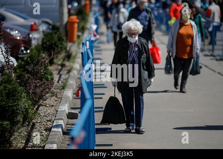 Bucarest, Romania - 16 aprile 2020: Gli anziani che indossano maschere protettive fanno il loro shopping in un mercato aperto occupato a Bucarest durante l'epidemia di covid-19 Foto Stock