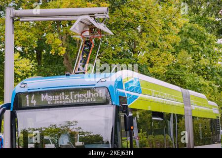 26 luglio 2022, Munster, Germania: L'autobus elettrico viene caricato dopo il completamento della rotta cittadina. Il problema dell'ecologia e dell'energia verde nel trasporto pubblico Foto Stock