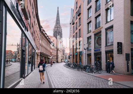 25 luglio 2022, Munster, Germania: Strada della città vecchia con la Torre della Chiesa di San Lamberti sullo sfondo. Foto Stock