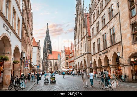 26 luglio 2022, Munster, Germania: Prinzipalmarkt - folle di turisti nella famosa via dello shopping e attrazione turistica. Torre di San Lamberti a backgrou Foto Stock