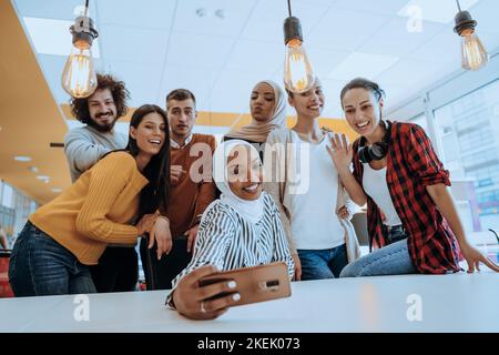 Gruppo del team degli uomini d'affari che scatta foto al selfie sul telefono cellulare in un moderno spazio aperto per lavorare in ufficio Foto Stock