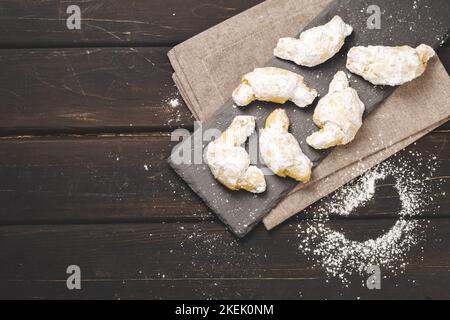 Biscotti arrotolati tradizionali ebraici Rugelach o Kifli Crescent ricoperti di zucchero a velo. Shortcrust appena sfornato Pasticceria croissant Confezione Foto Stock