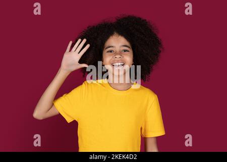 Ritratto di allegra ragazza capretto afroamericana che ondola alla macchina fotografica Foto Stock