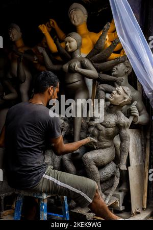 Kolkata, India - 28 agosto 2022: Un idol maker fare un idolo di argilla all'interno di idol fare studio per Durga Puja festival. Messa a fuoco selettiva sulla faccia o Foto Stock