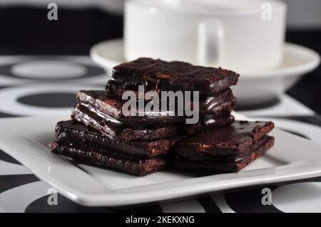 Biscotti ricoperti di cioccolato su un piatto bianco Foto Stock