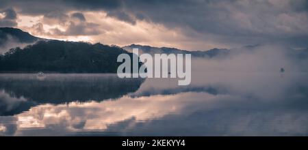 La prima mattina nebbia e la bassa nuvola pende su Derwentwater, English Lake District. Foto Stock