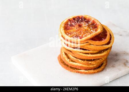 Una pila di fette di arancia disidratate speziate con cannella e zucchero. Foto Stock