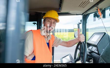 Lavoratore di costruzione su escavatore che progetta il lavoro da fare Foto Stock