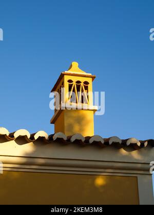 Camino giallo su una casa in Algarve in Portogallo meridionale. Foto Stock
