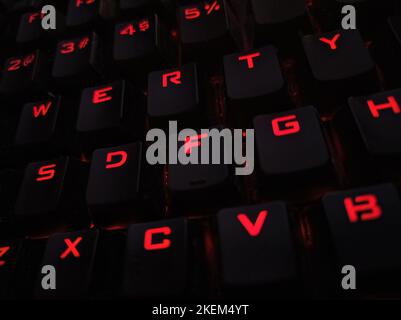 Primo piano della tastiera retroilluminata. Tasti neri con caratteri illuminati. Tastiera per giochi con retroilluminazione. Tastiera con retroilluminazione LED RGB per giochi Foto Stock