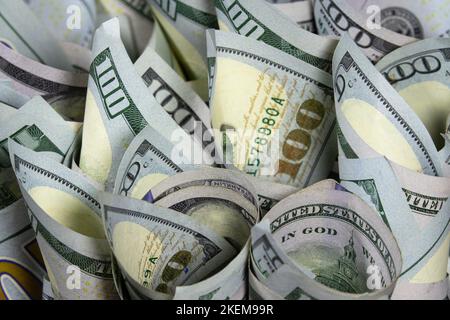 Primo piano di cento banconote di dollari americani rotolate in un tubo. Concetto bancario e finanziario Foto Stock