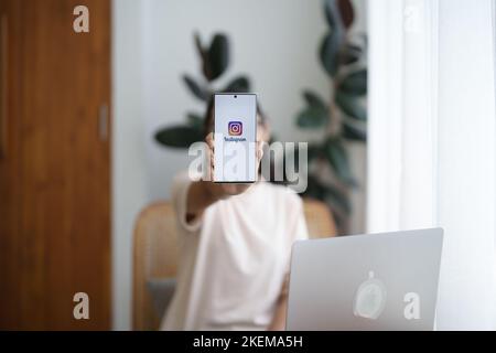 CHIANG mai, THAILANDIA - 09 luglio 2022: Una donna tiene smartphone android con l'applicazione Instagram sullo schermo al bar. Foto Stock