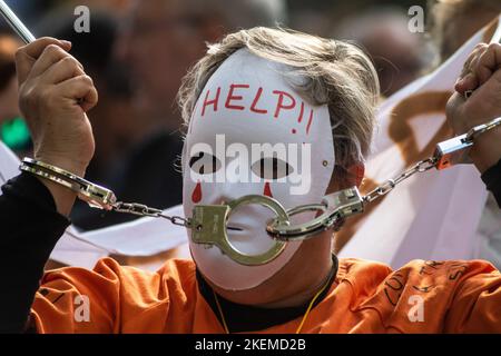 Madrid, Spagna. 13th Nov 2022. Un protester manettato e indossato una maschera è visto durante una dimostrazione per difendere il sistema di salute pubblica. Circa 200.000 persone hanno marciato in Piazza Cibeles per protestare contro la gestione del Servizio di Assistenza primaria di Madrid. Credit: Marcos del Mazo/Alamy Live News Foto Stock