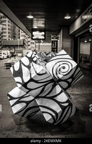 Una scala di grigi verticale di una scultura astratta di fronte a un edificio, la città di Atlanta Foto Stock