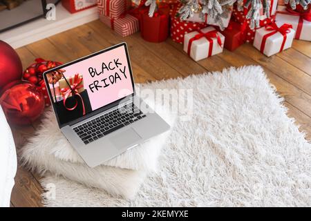 Concetto di shopping del Black Friday scritto sullo schermo nero del notebook contro lo sfondo sfocato delle luci di natale Foto Stock