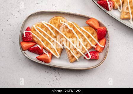 Waffle belgi a forma di cuore con fragole Foto Stock