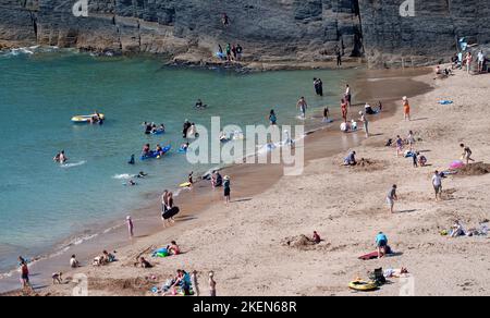 Spiaggia affollata di turisti in estate in Mwnt Cardigan Ceredigion REGNO UNITO Galles Foto Stock