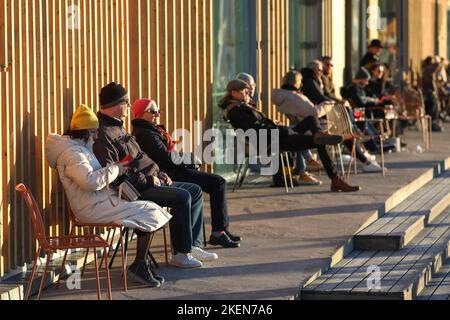 Helsinki, Uusimaa, Finlandia. 12th Nov 2022. La Giornata del Padre in Finlandia si celebra la seconda domenica di novembre. Non si tratta di una festa pubblica ufficiale in Finlandia, ma la gente la festeggia comunque in questo fine settimana, a causa dell'importanza dei padri, dei padri e dei padri per la famiglia e per la cultura finlandese. La gente esce con la famiglia o festeggia a casa. Le persone si sedono sulla terrazza del ristorante Allas e godono di una giornata di sole il sabato prima del giorno del Padre. (Credit Image: © Marina Takimoto/ZUMA Press Wire) Foto Stock