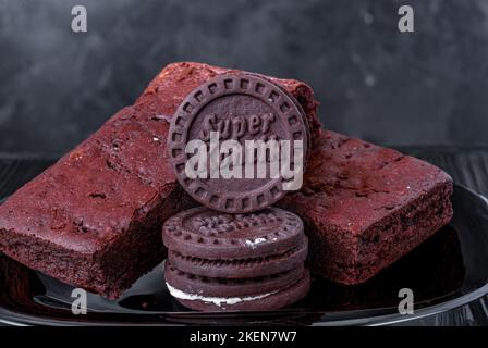 brownie con biscotti su una pietra su uno sfondo nero Foto Stock