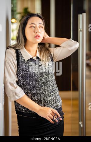 Giovane scienziata di dati femminile in attesa alla porta di una sala conferenze Foto Stock