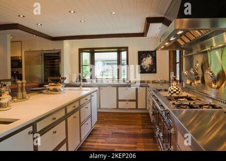 Cucina di stile country con isola e stufa a gas all'interno di New Hampton style casa, Quebec, Canada. Foto Stock