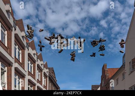 Nuova Street art Shoefiti, allenatori appesi al guinzaglio nella zona pedonale, Lueneburg, bassa Sassonia, Germania Foto Stock