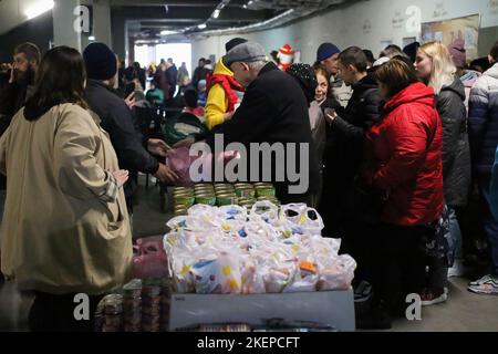 Sfollati interni con i loro figli visti in coda per ricevere pacchi di cibo durante la Giornata di sostegno degli sfollati. Una giornata di sostegno agli sfollati interni, gli sfollati interni hanno avuto luogo nel parcheggio dello stadio di Chernomorets. L'organizzatore è la Fondazione benefica 'Trimai'. Il programma comprende l'emissione di pacchetti alimentari agli sfollati, la raccolta di fondi per le necessità delle forze armate ucraine, la raccolta di cibo per l'alimentazione degli animali abbandonati, un concerto di una banda di ottone 'banda di concerti comunali'. Foto Stock