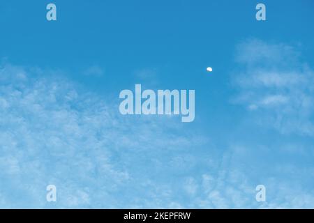 Mezza luna in cielo di giorno con nuvole wisy atmosfera ambiente. Naturale luna e cielo sfondo texture, la forma libera bellezza di nuvole e cielo Foto Stock