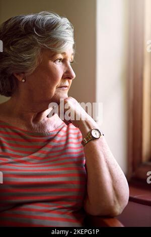 Alcuni ricordi non svaniscono mai. Una donna anziana che guarda premurosa. Foto Stock