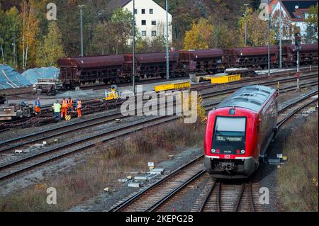 Bayreuth, Germania. 12th Nov 2022. I lavoratori dei binari lavorano su rotaie mentre un treno della Deutsche Bahn arriva verso la stazione centrale. La linea Franconia-Sassonia da Norimberga a Dresda non deve essere elettrificata nella sezione bavarese. I treni diesel continueranno a circolare qui. (A dpa 'polemica su 'isola di diesel' della ferrovia nel nord della Baviera') Credit: Daniel Vogl/dpa/Alamy Live News Foto Stock