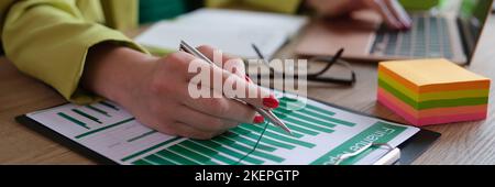 Dipendente analista che lavora con report finanziari su computer e documenti Foto Stock