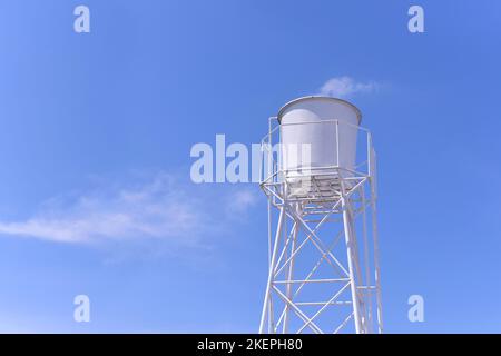 Serbatoio di acqua bianca nel villaggio, approvvigionamento idrico con sfondo blu nuvola cielo. Foto Stock