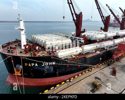 LIANYUNGANG, CINA - 14 NOVEMBRE 2022 - la foto aerea mostra le navi da carico che caricano i camion di riempimento speciali per l'esportazione in Africa ad un molo in Lianyungang C. Foto Stock