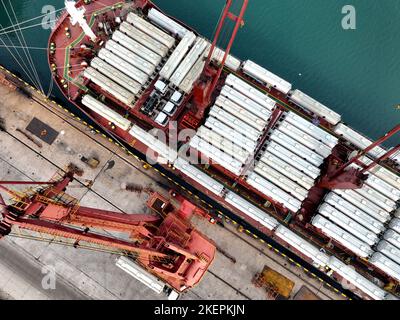 LIANYUNGANG, CINA - 14 NOVEMBRE 2022 - la foto aerea mostra le navi da carico che caricano i camion di riempimento speciali per l'esportazione in Africa ad un molo in Lianyungang C. Foto Stock