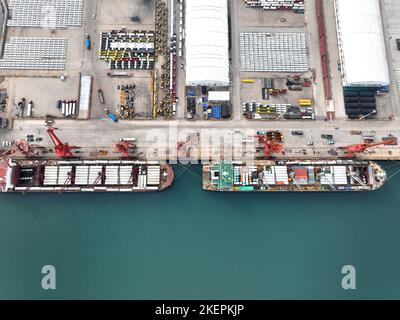 LIANYUNGANG, CINA - 14 NOVEMBRE 2022 - la foto aerea mostra le navi da carico che caricano i camion di riempimento speciali per l'esportazione in Africa ad un molo in Lianyungang C. Foto Stock