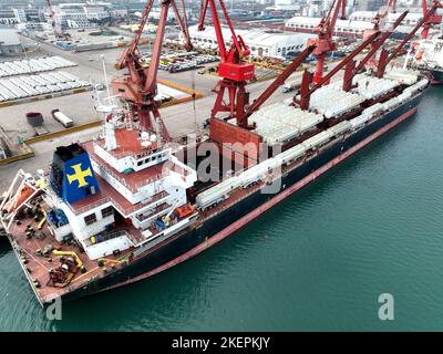 LIANYUNGANG, CINA - 14 NOVEMBRE 2022 - la foto aerea mostra le navi da carico che caricano i camion di riempimento speciali per l'esportazione in Africa ad un molo in Lianyungang C. Foto Stock