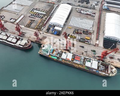 LIANYUNGANG, CINA - 14 NOVEMBRE 2022 - la foto aerea mostra le navi da carico che caricano i camion di riempimento speciali per l'esportazione in Africa ad un molo in Lianyungang C. Foto Stock
