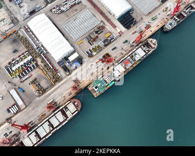 LIANYUNGANG, CINA - 14 NOVEMBRE 2022 - la foto aerea mostra le navi da carico che caricano i camion di riempimento speciali per l'esportazione in Africa ad un molo in Lianyungang C. Foto Stock