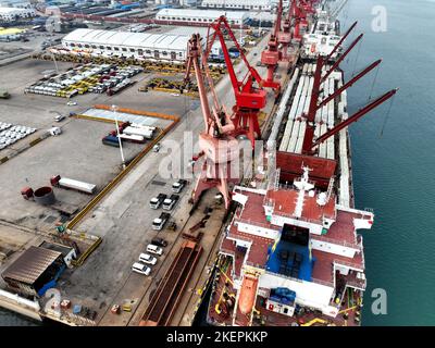 LIANYUNGANG, CINA - 14 NOVEMBRE 2022 - la foto aerea mostra le navi da carico che caricano i camion di riempimento speciali per l'esportazione in Africa ad un molo in Lianyungang C. Foto Stock