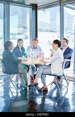 Sessione strategica in corso. Un gruppo di imprenditori che si riunisce in una sala consiliare. Foto Stock